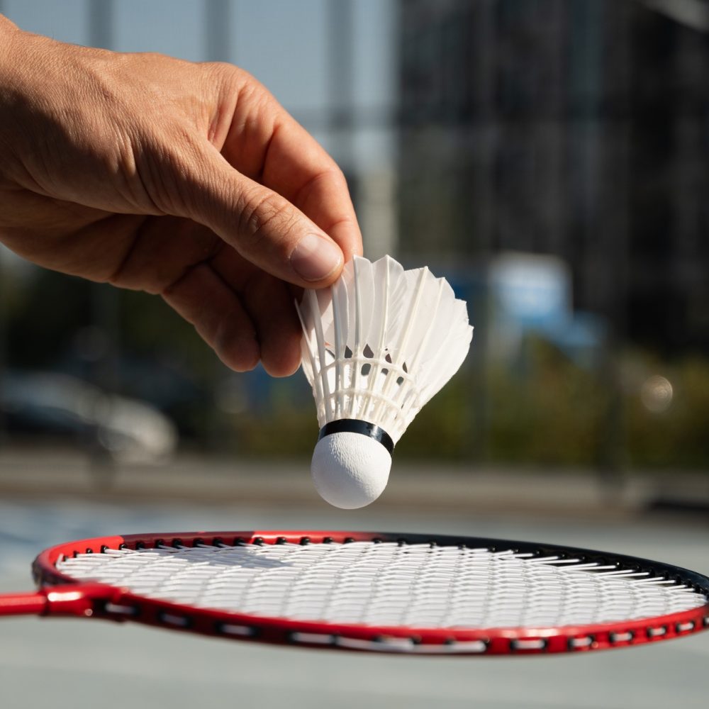 White badminton shuttlecock and badminton rackets on floor sport badminton. Outdoors. Close up.